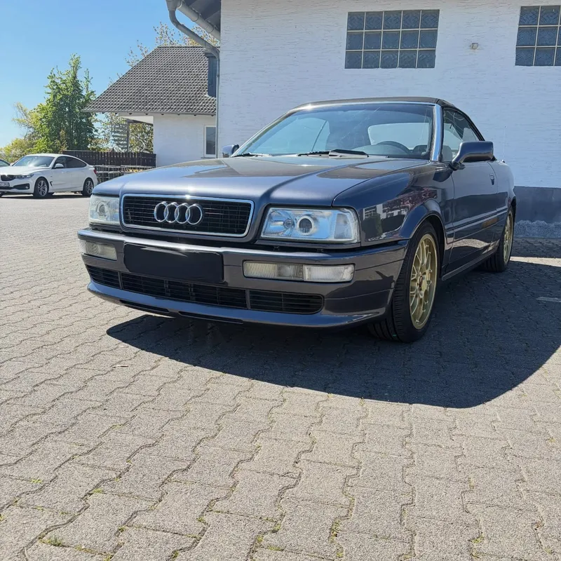 Dunkelblaues Audi Cabriolet mit goldenen Felgen