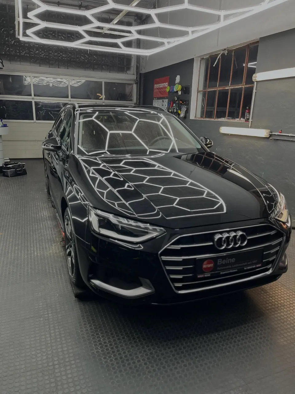 Schwarzer Audi A4 Avant unter dem Wabenlicht der Werkstatt