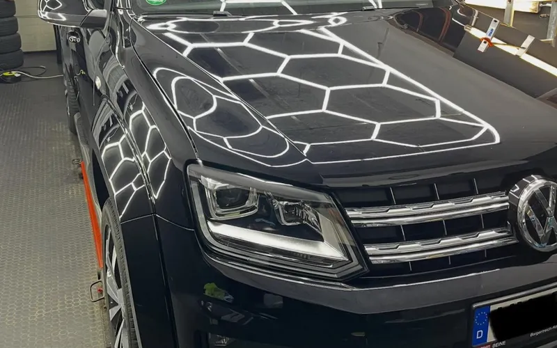 Dunkler VW SUV unter dem Wabenlicht der Werkstatt