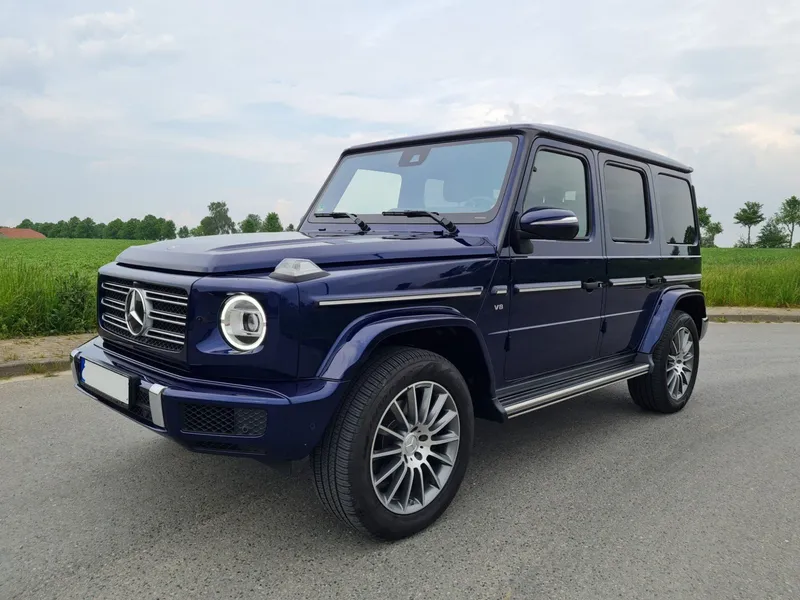 Dunkelblaue Mercedes G-Klasse vor Feldern