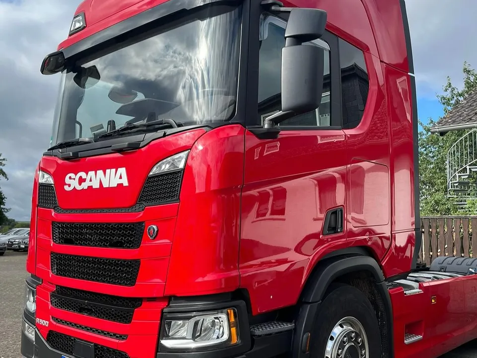 Rote Scania-Zugmaschine nach der Aufbereitung unter dramatischem Himmel