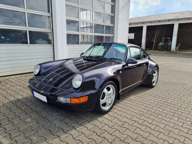 Dunkler Porsche 911 der Baureihe 964 vor der Halle