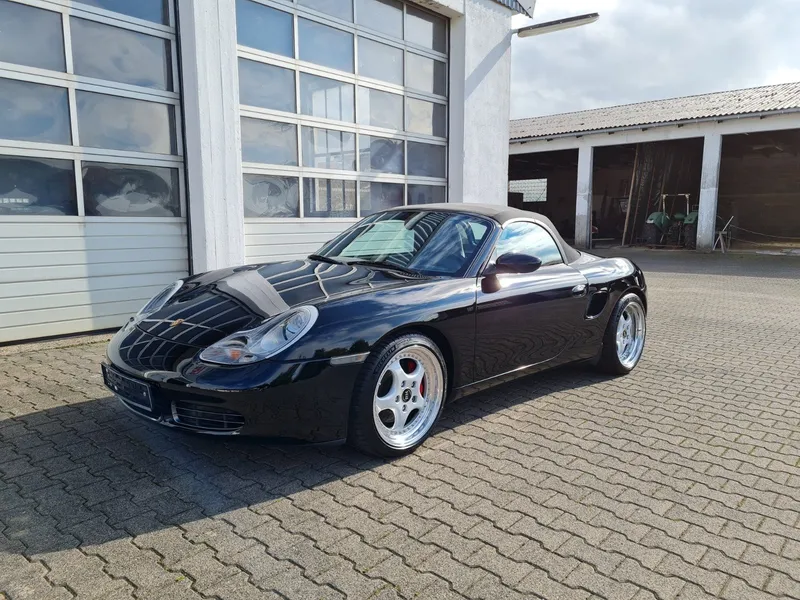 Schwarzer Porsche Boxster vor der Halle