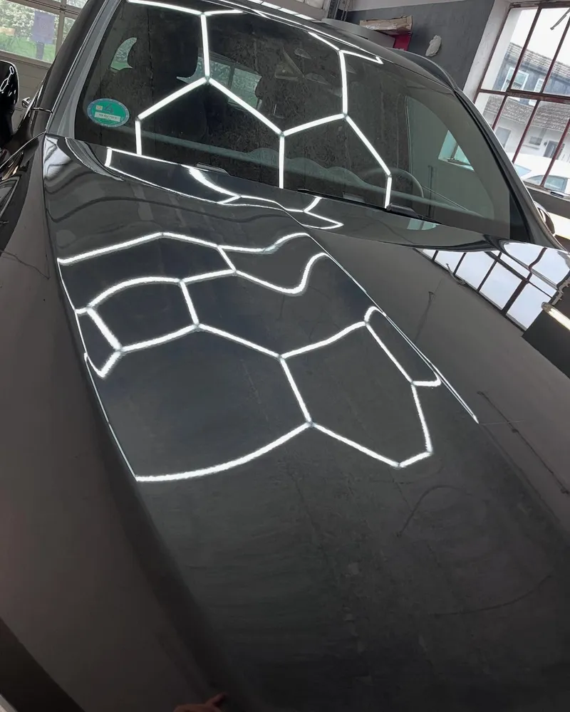 Wabenlicht spiegelt sich in der frisch polierten schwarzen Motorhaube